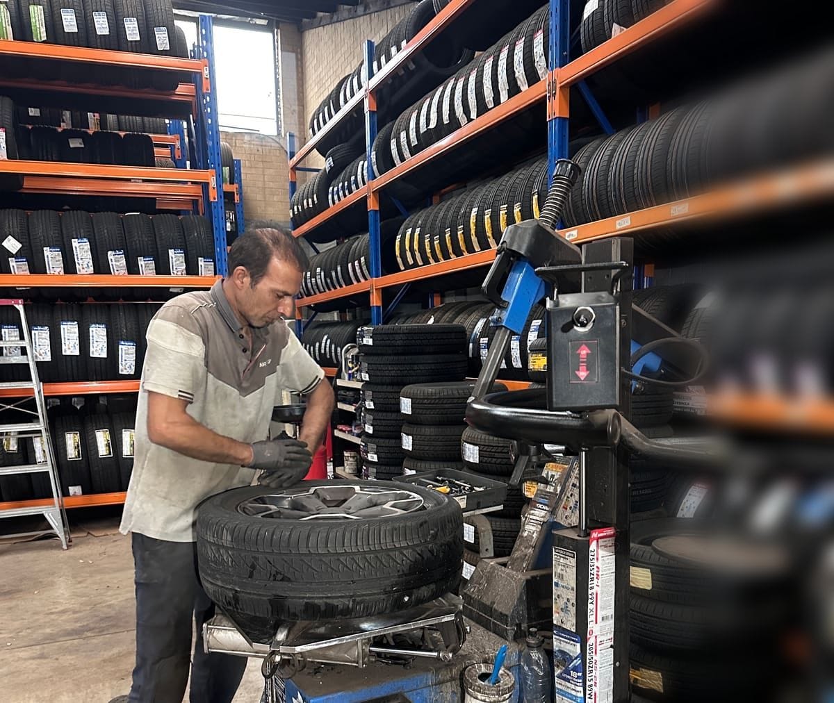 A man working at the tyre changer in the workshop